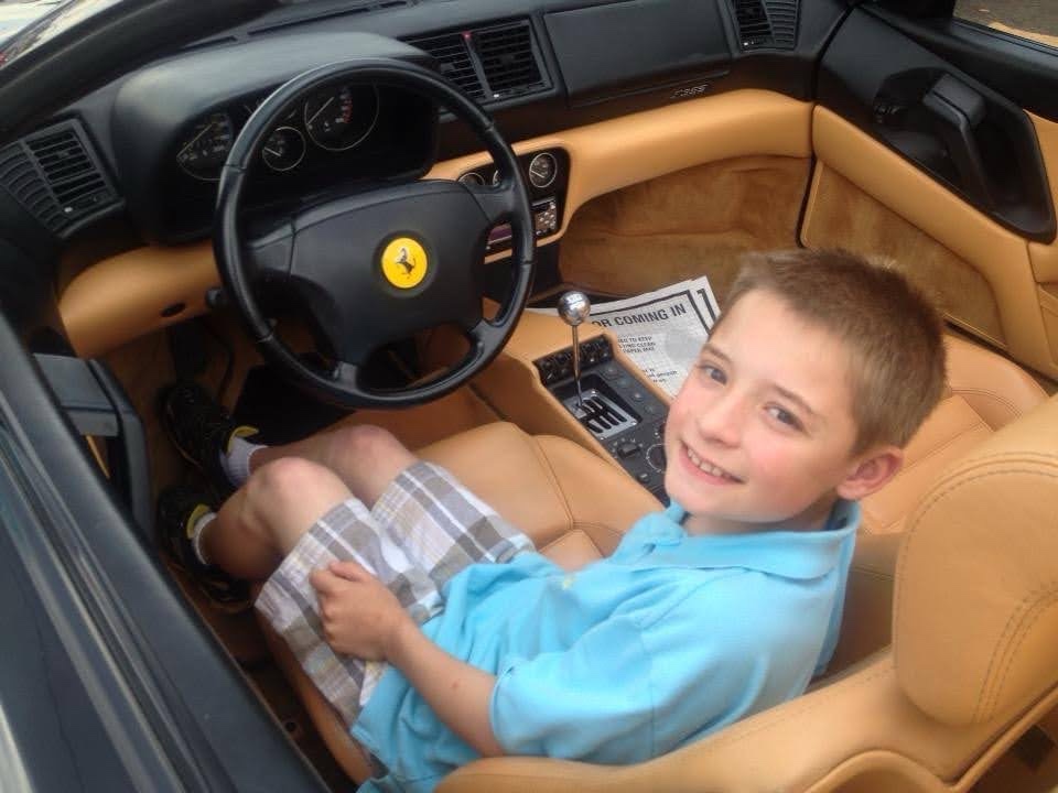 Charlie as a child in a Ferrari